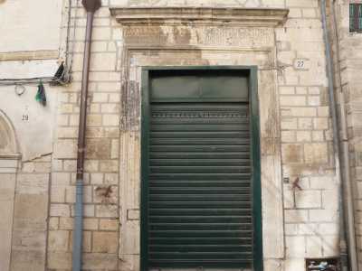 ...e la fondazione muraria che appare in forte contrasto con la moderna saracinesca verde di un negozio con cui convive